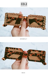 Detail showing oversized tortoise shell sunglasses frame with sparkling rhinestone border