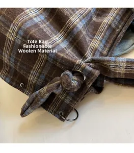 Close-up of brown plaid corduroy tote bag showing textured wool fabric and metal eyelets