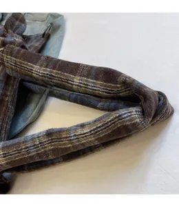 Detail of durable plaid woolen handle and metal ring on corduroy shoulder bag
