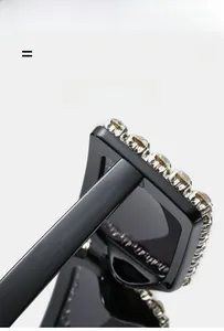 Detail view of black square sunglasses with sparkling rhinestones on the frame