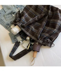Macro shot of large plaid tote bag interior storing daily essentials on blue denim jacket