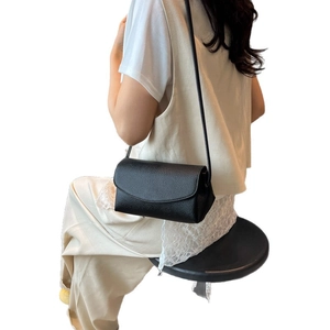 Chic black litchi leather crossbody bag for women with minimalist curved flap design