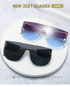 Detail of oversized one-piece sunglasses with gradient lenses and gold metal accents