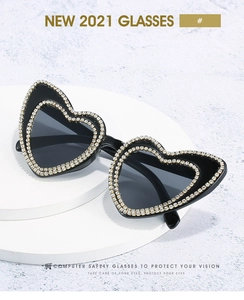 Close-up of sparkling rhinestones on the black heart-shaped frames of these luxury sunglasses