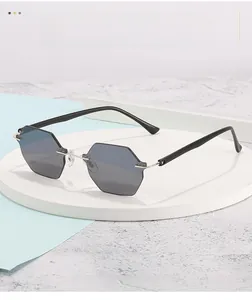 Detail of rimless hexagonal sunglasses with gradient grey lenses and metallic bridge