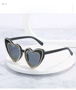 Detail of heart-shaped sunglasses with double-row sparkling rhinestones on the frame