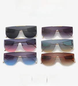 Detail view of oversized flat top sunglasses with gradient lenses and metal rivet accents
