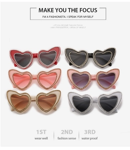Close-up of heart-shaped sunglasses in six colors with diamond-studded frame edges