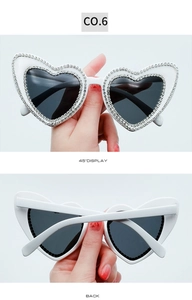 Detailed view of heart-shaped sunglasses featuring two rows of inlaid rhinestones