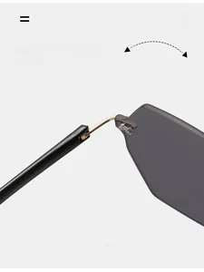 Detail of durable gold metal hinge on rimless sunglasses with gray gradient lenses