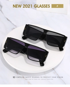 Gros plan de lunettes de soleil carrées noires élégantes avec des détails dorés chic