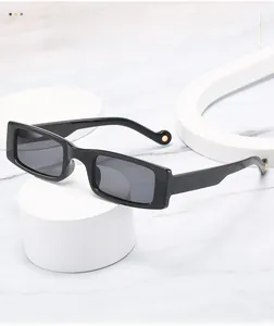 Detail of black rectangular sunglasses with curved temples and gold metal accents