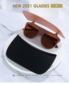 Detail view of flip-up sunglasses with matte brown frames and detachable eye shields