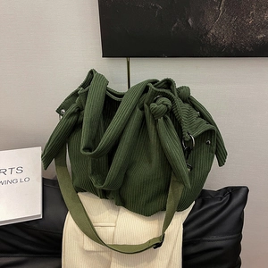 Dark green corduroy tote bag with knotted wide strap and adjustable crossbody strap