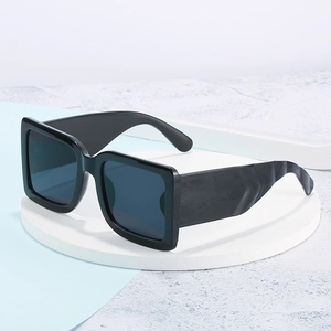 Classic black square frame sunglasses with deep blue lenses on a white display pedestal