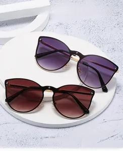 Close-up of cat-eye rimless sunglasses with gradient lenses and metal rivet details