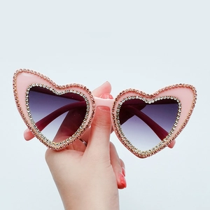 Pink heart-shaped sunglasses with sparkling rhinestone frame and gradient purple lenses