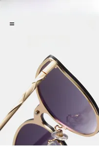 Detailed close-up of gold metal frame sunglasses with gradient lenses and textured temples