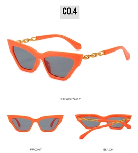 Detail view of orange cat-eye sunglasses featuring unique chunky gold chain temples