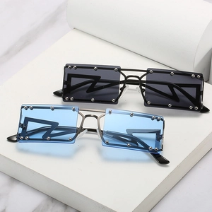 Square rivet sunglasses with blue and black lenses on white marble display