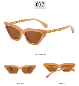 Cat eye sunglasses detail with translucent orange frame and golden metal chain temples