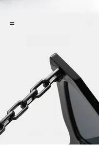Close-up of stylish black cat eye sunglasses with heavy industrial chain temple detail