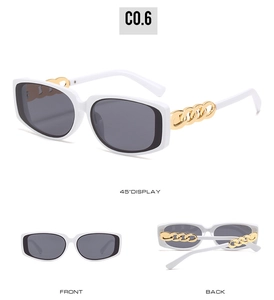 Detail view of white square sunglasses featuring bold gold chain temples and gray lenses