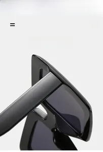 Detail view of glossy black square sunglasses frame and premium flexible hinge texture