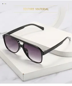 Close-up of classic aviator sunglasses with purple gradient lenses on a marble base
