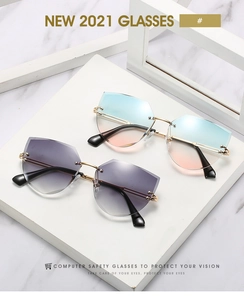 Close-up of rimless geometric cat-eye sunglasses with gradient lenses and gold metal frame