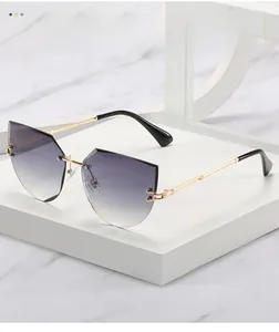 Detail of rimless cat-eye sunglasses with gradient purple lenses and gold metal arms