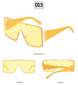 Drei Ansichten der gelben Oversize-Sonnenbrille mit Nieten und geometrischen Bügeln im Detail