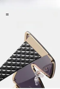 Details einer quadratischen Oversize-Sonnenbrille mit Steppmuster und Goldmetallrand