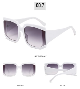 Détail de lunettes de soleil carrées blanches avec verres dégradés violets et branches larges