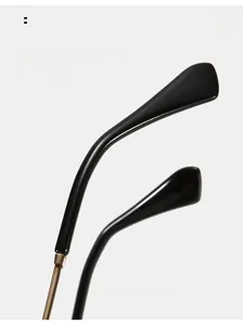 Detailed macro view of curved black ergonomic temple tips with golden metal accents