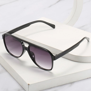 Classic pilot sunglasses with black frame and purple gradient lenses on marble background