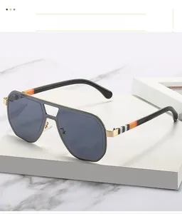 Detail of pilot sunglasses with gold metal frame and striped pattern on the temples