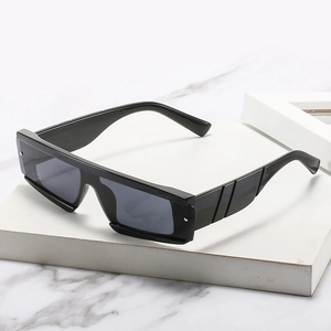 Lunettes de soleil rectangulaires noires modernes avec branches larges sur marbre
