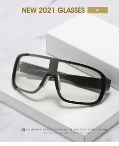 Détail de lunettes de cyclisme avec monture noire et verres clairs sur fond marbre