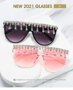 Nahaufnahme der Oversize-Sonnenbrille mit Strassfransen und Verlaufsgläsern auf Requisiten