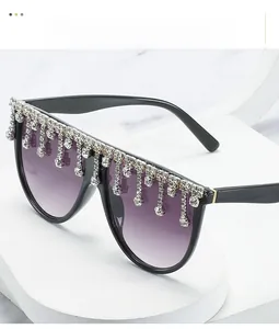 Detail der übergroßen schwarzen Sonnenbrille mit lila Farbverlauf und Strass-Fransen