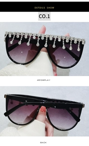 Detailansicht der Oversize-Sonnenbrille mit lila Farbverlauf und Strass-Quasten