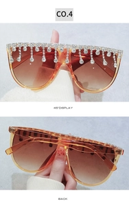 Detail der übergroßen Bernstein-Sonnenbrille mit Verlaufsgläsern und Strass-Fransen-Design