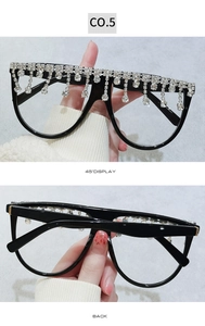 Detail der übergroßen schwarzen Brille mit Kristallfransenbesatz am oberen Brillenrand