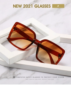 Détail des lunettes de soleil carrées rétro ambre avec rivets et verres dégradés orange