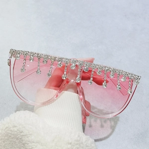 Übergroße rosa Sonnenbrille mit glitzernden Strassfransen und hellen Gläsern