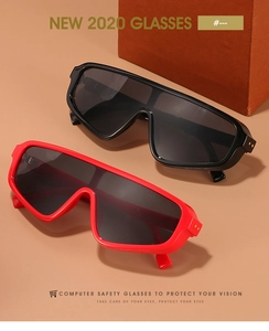 Detail of oversized one-piece sunglasses with gold rivets in black and red frames