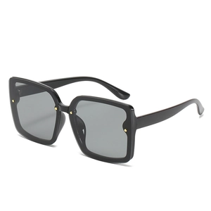 Lunettes de soleil carrées rétro noires avec rivets dorés et verres gris UV en vue de 45 degrés