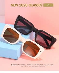 Détail de lunettes de soleil carrées noires et crème sur des supports géométriques