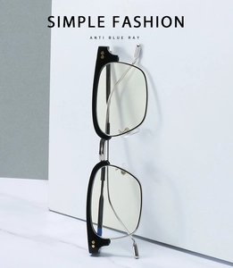 Detail view of anti-blue light glasses with black and silver square frames and thin temples